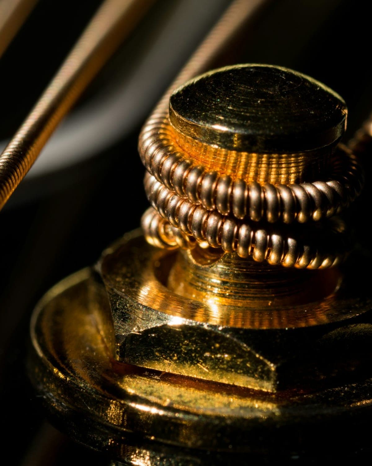 A close-up of a hand-wound gold vape coil
