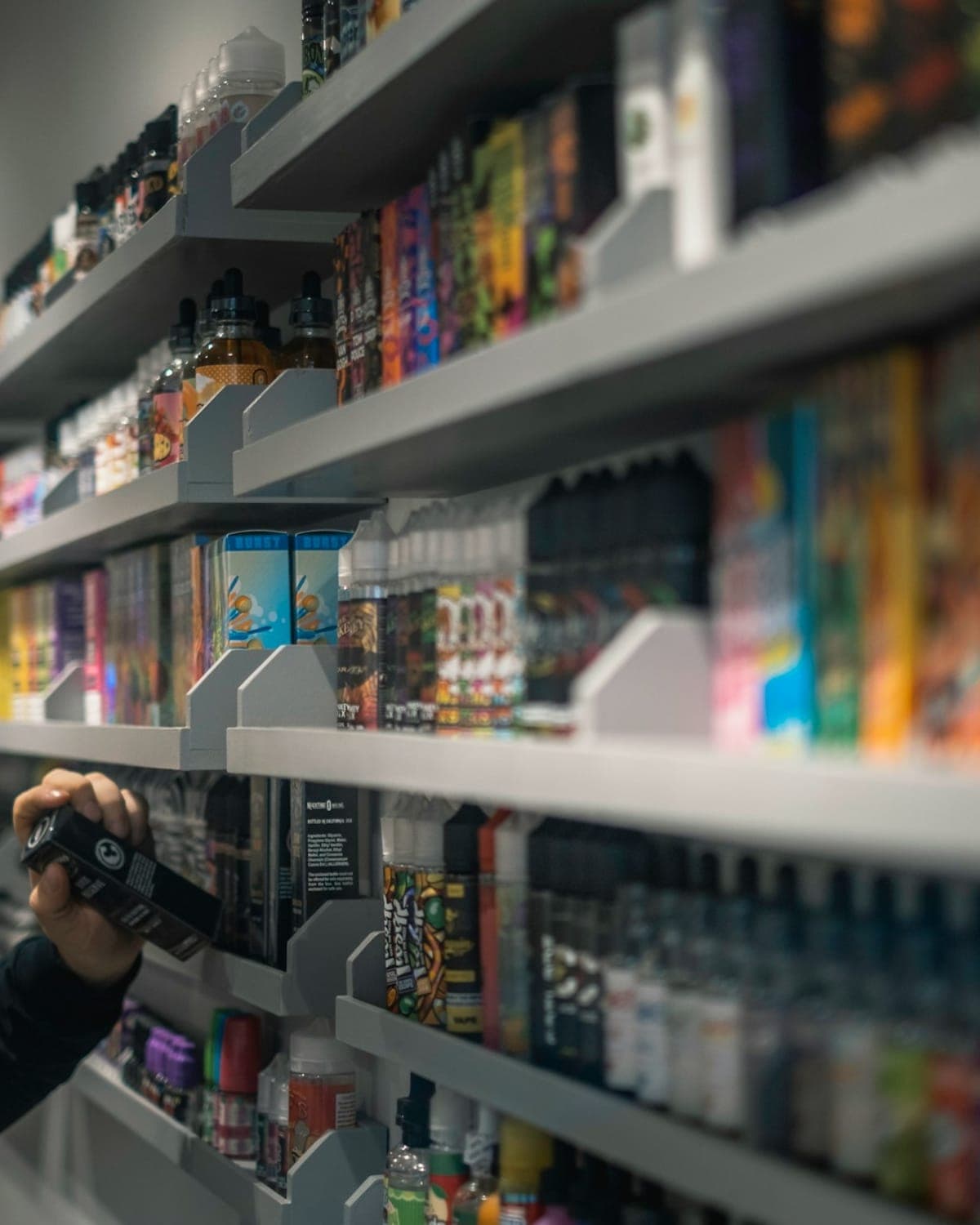A long wall of shelves stacked with colourful e-liquid bottles